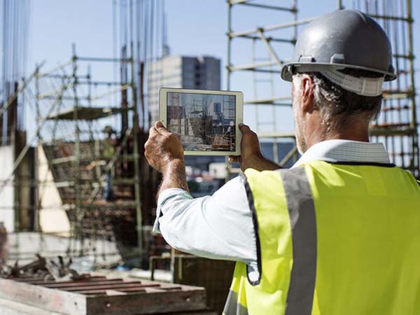 Construction professional reviewing building plans at a commercial project site